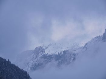 Low angle view of snow covered mountain against sky