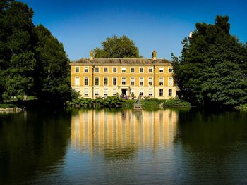 Building by lake against clear sky