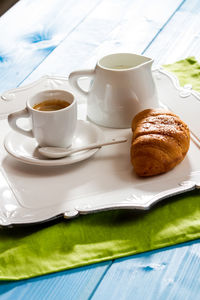 Espresso with croissant on table