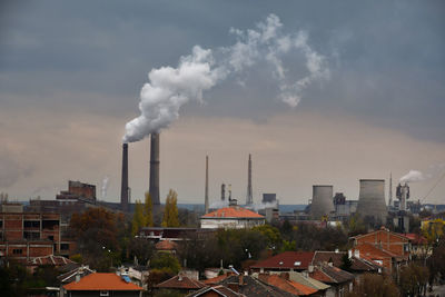 Smoke emitting from chimney against sky