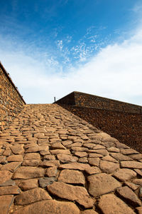 Low angle view of stone wall against sky