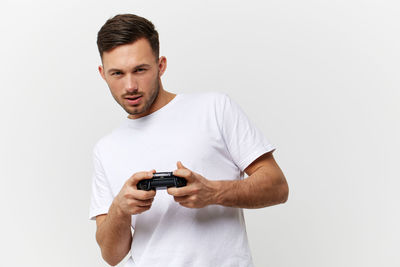 Young man using phone against white background