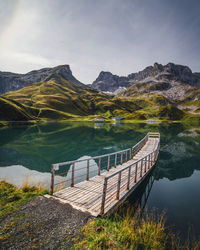 Empty jetty in lake against sky