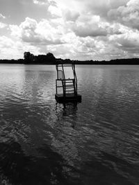 Silhouette boat in lake against sky