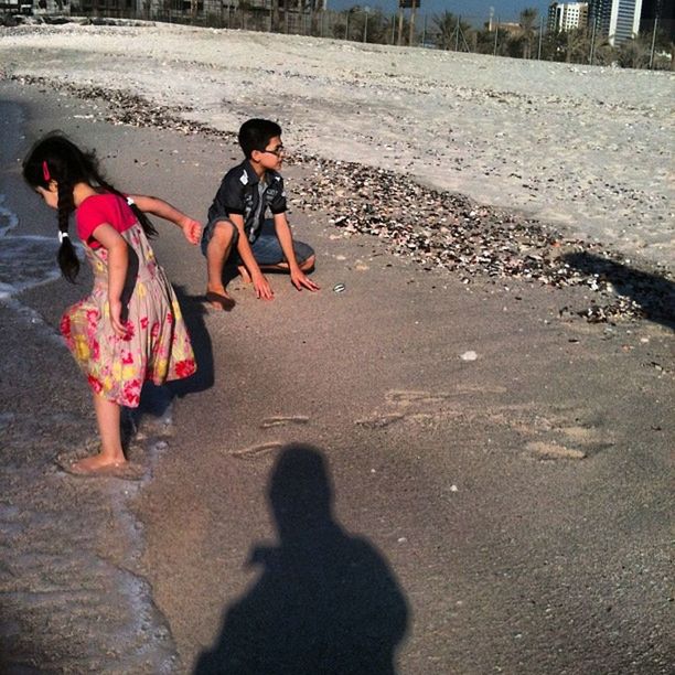 lifestyles, full length, leisure activity, street, childhood, casual clothing, boys, road, elementary age, person, sand, beach, girls, sunlight, day, walking, outdoors, shadow