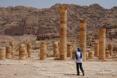 Rear view of woman standing on ancient ruins