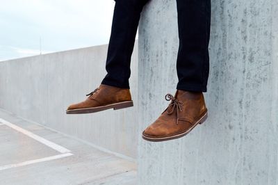 Low section of man dangling against wall