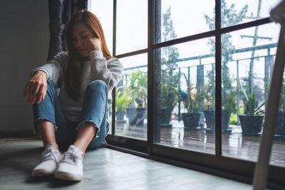 A sad and stressed young asian woman sitting alone in the room