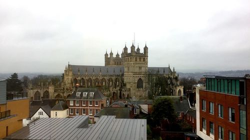 Buildings in city against cloudy sky