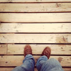 Low section of woman standing on wooden plank