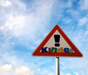 Low angle view of road sign against sky