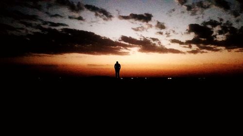 Silhouette man standing against sky during sunset