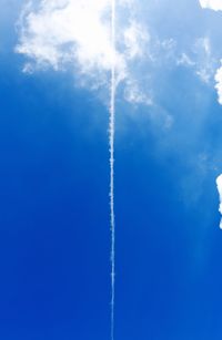 Low angle view of vapor trail against blue sky