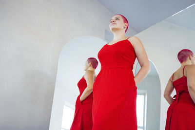 Young woman standing against wall