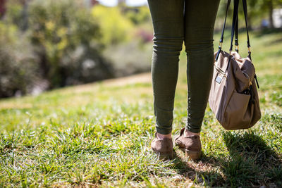 Low section of woman standing on grass