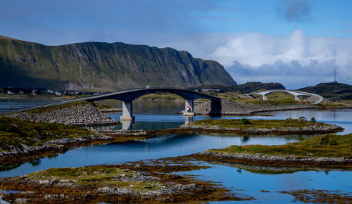 Arch bridge over river against sky
