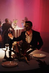 Young man sitting at illuminated table