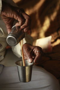 Cropped hand pouring coffee in glass