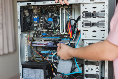 Cropped hands of woman repairing computer equipment