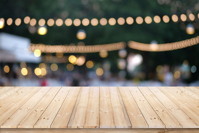 Close-up of illuminated lights on wooden floor at night