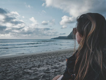 Portrait of woman on beach against sky