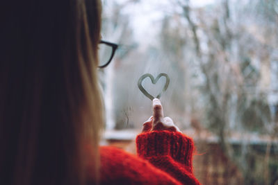 Close-up of woman with heart shape in winter