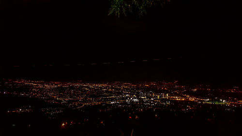 Illuminated cityscape against sky at night