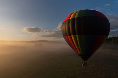 Hot air balloon flying over landscape against sky