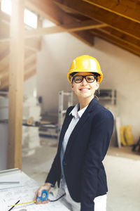 Architect wearing hardhat while working at construction site