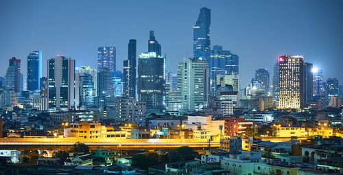 Illuminated buildings in city against sky