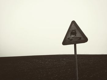 Close-up of road sign against sky