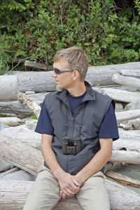 Man sitting on driftwood at pacific rim national park reserve