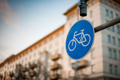 Low angle view of road sign against building in city