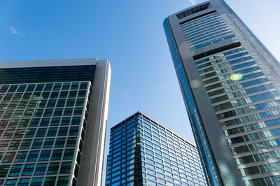 Low angle view of modern buildings against blue sky