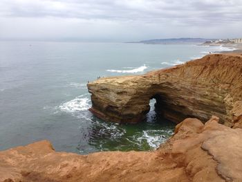 Rock formations by sea against sky