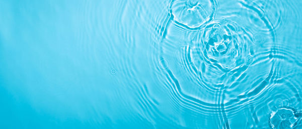 Transparent blue colored clear calm water surface texture