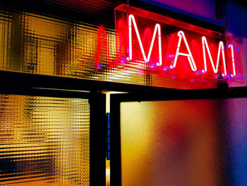 Low angle view of illuminated text on building at night