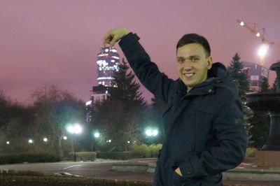 Portrait of smiling man standing at night