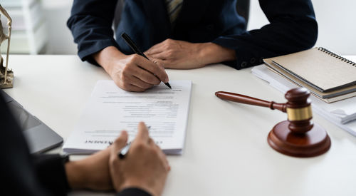 Midsection of lawyer working on table
