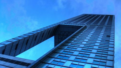 Low angle view of modern building against blue sky