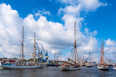 Sailboats in harbor against sky