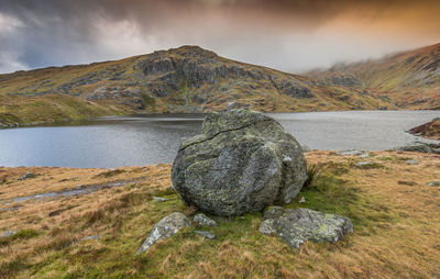 Scenic view of rocks by lake against sky