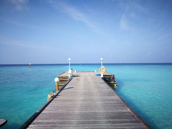 Pier over sea against blue sky