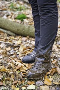 Low section of person standing on autumn leaves