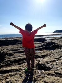 Rear view of woman standing on beach