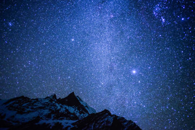 Scenic view of mountains against blue sky at night