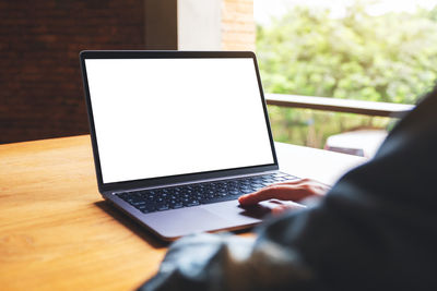 Cropped hands using laptop on table