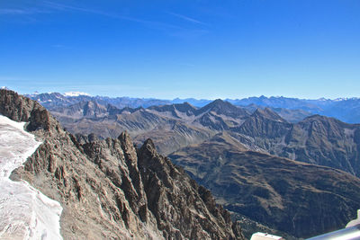 Scenic view of mountains against blue sky