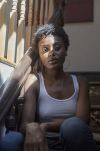 Portrait of a young woman sitting in a staircase