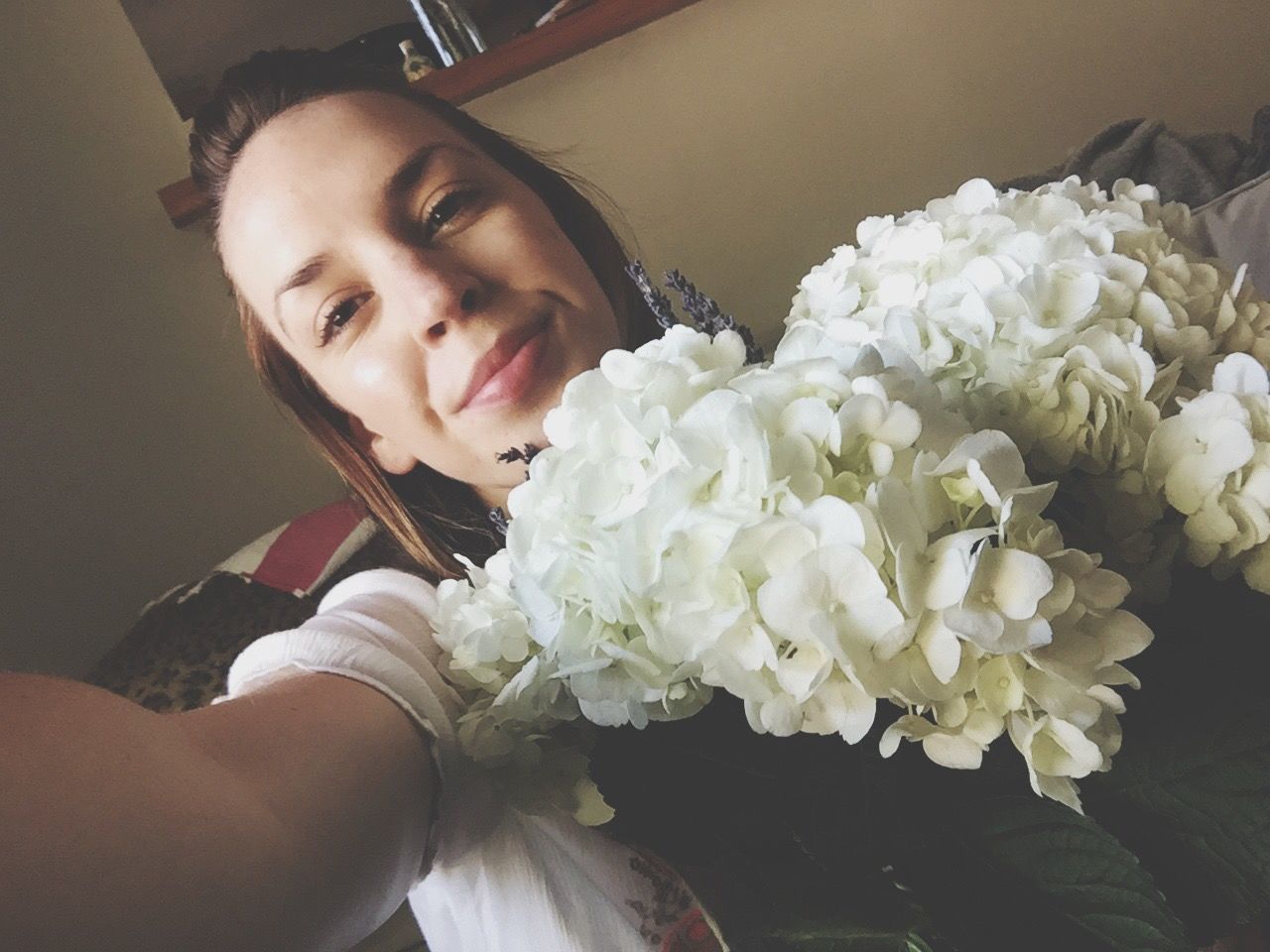 flower, freshness, fragility, indoors, portrait, looking at camera, holding, beauty in nature, bouquet, petal, flower head, bunch of flowers, softness, springtime, nature, botany, focus on foreground, young adult